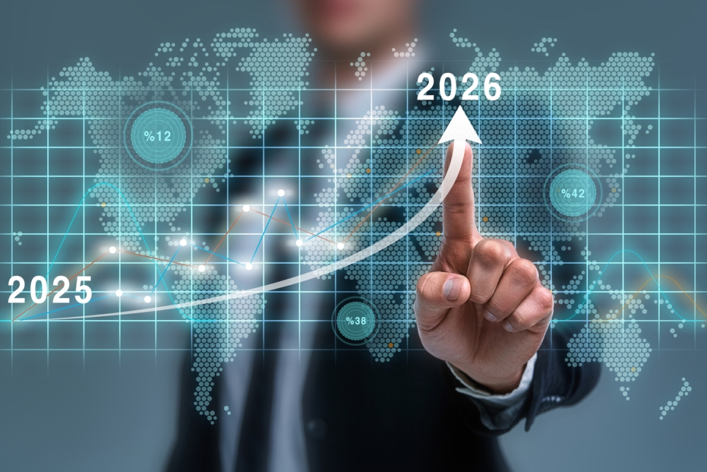 A person in a suit points at a rising arrow on a digital screen, marking growth from 2025 to 2026, with a world map and data graphics in the background, symbolizing global business or financial progress.