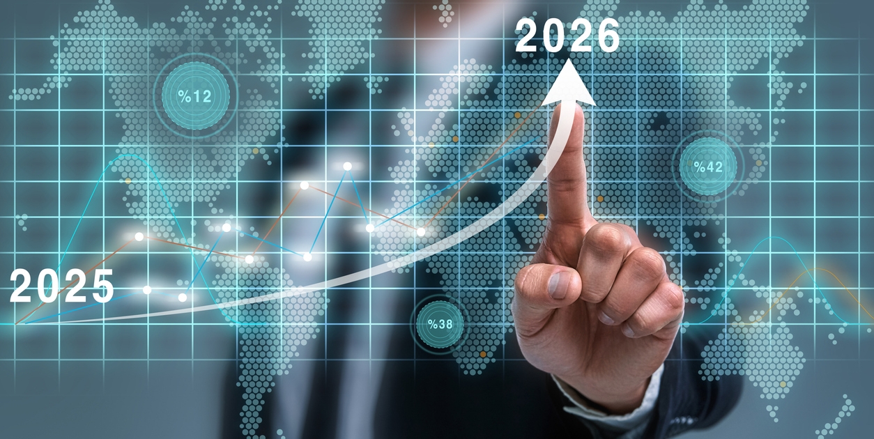 A person in a suit points at a rising arrow on a digital screen, marking growth from 2025 to 2026, with a world map and data graphics in the background, symbolizing global business or financial progress.