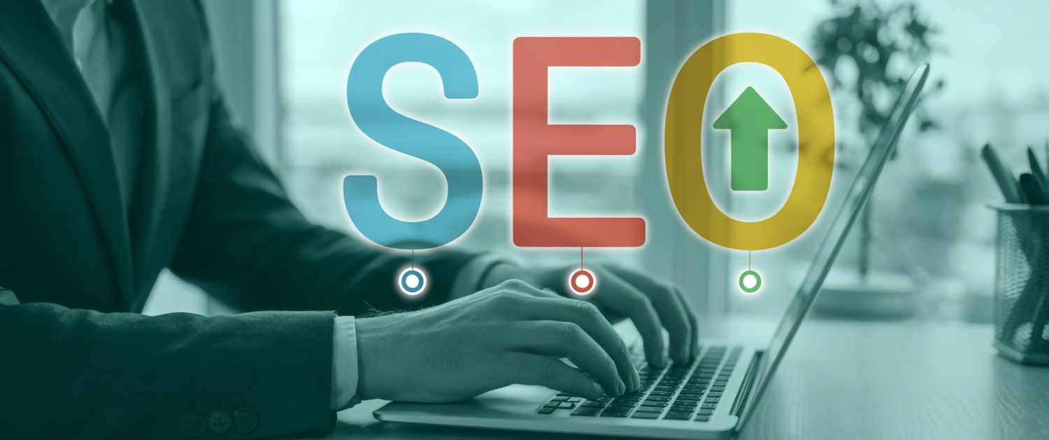 A person in business attire types on a laptop, with large translucent letters SEO and an upward arrow overlaying the image, symbolizing search engine optimization and growth.