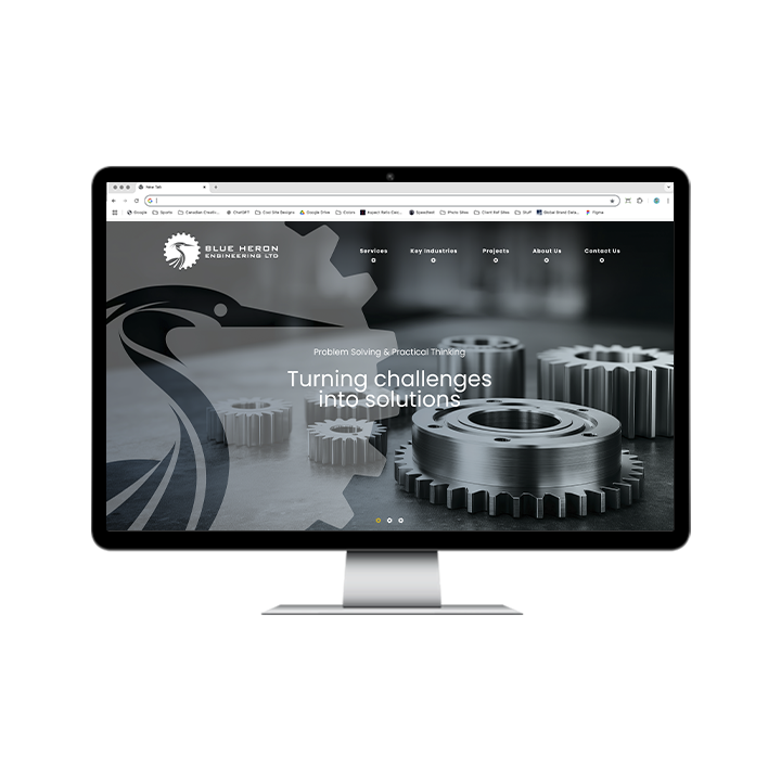 AG Client Page Blue Heron BV1 A desktop computer monitor displaying the Blue Heron Engineering Ltd. website, featuring a logo, navigation menu, and the headline Turning challenges into solutions over an image of mechanical gears.