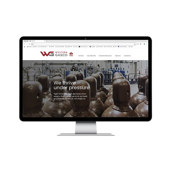 AG Client Page Western Gasco BV2 Desktop computer displaying the Western Gasco website homepage, featuring a banner with many brown gas cylinders and the text We thrive under pressure.